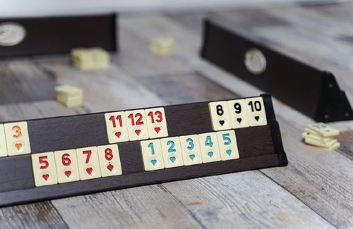 لعبة  اوكية  بني غامج - لعبة رومي او لعبة الأوكي التركية الشهيرة تعتبر من اللعب التاريخية المنتشرة و المشهورة في تركيا و الهند و دول اوروبا. تعد هذه اللعبة عالمية و قريبة جدا من لعبة الهاند الشهيرة &nbsp;كيف تلعب الرومي ؟من لاعبين الى 4 لاعبين والعمر 7 سنوات فما فوقالهدف:أن تكون أول لاعب يقوم بالتخلص من جميع البلاطات الخاصة به عن طريق وضعهم في مجموعات. حاول ان تبقي على أقل عدد من
النقاط على الرف الخاص بك. في بداية اللعبة تحدد كم نقطة تحتاج إلى أن تصل إنهاء اللعبة .المحتويات :
106 بلاطات مجموعتين من البلاط مرقمة من 1 إلى 13 بأربعة ألوان: أسود، أحمر، أزرق، برتقالي وعدد 2 جوكر.
4 أرفف للعبالتجهيز للعب :ضع البلاطات في حقيبة و قم بخلطهم جيدا. كل لاعب يقوم باختيار بلاطة ، صاحب أعلى رقم يقوم بالبدء أولا و من ثم اللاعب الآخر
باتجاه عقارب الساعة. نعيد البلاطات إلى الحقيبة و من ثم نخلطهم جيدا. كل لاعب يأخذ 14 بلاطة و يقوم بوضعهم على الرف
الخشبي الخاص به.اللعب :يوجد هناك نوعين من المجموعات
النوع أ : هو مجموعة من 3 او 4 بلاطات من نفس الرقم ولكن بألوان
مختلفة
النوع ب : هي مجموعة من ثلاثة أرقام متتالية أو أكثر ، وكلها بنفس اللون.
.يتم لعب الرقم 1 دائما على أنه أقل رقم لا يمكن ان يتبع بالرقم 13 لتنزيل البلاطات على الطاولة كل لاعب يجب ان يمتلك على الأقل 30 نقطة كمجموعة واحدة او في عدة مجموعات.
هذه النقاط يجب ان يتم تجميعها من بلاطات اللاعب نفسه و ليس من البلاطات التي على الطاولة. قيمة البلاطة تحدد بالرقم المكتوب عليها ،
الجوكر ممكن استخدامه بدل أي بلاطة&nbsp; و يتم احتساب قيمته حسب المكان الذي استخدم فيه. الغرامة في حالة الاحتفاظ بالجوكر و قام
لاعب آخر بالفوز هو 30 نقطة, في حالة كان اللاعب لا يستطيع المشاركة او اختار عدم المشاركة يجب عليه أن يأخذ بلاطة من
السحب و ينتهي دوره. بعد ان يقوم اللاعبين بالبداية باللعب ، يستطعون أيضا وضع بلاطاتهم في مجموعات اللاعبين الآخرين على الطاولة.
اذا كان اللاعب لا يستطيع ان يضيف على المجموعات في الطاولة يقوم اللاعب بأخذ بلاطة من السحب لينتهي دوره ، لا يستطيع
اللاعب ان يضع البلاطة التي قام بسحبها يجب عليه أن ينتظر دوره الثاني ، يستمر اللعب حتى يقوم احد اللاعبين بإنهاء جميع
بلاطاته و يصرخ&nbsp;رومي هذا ينهي الجولة و يقوم اللاعبين بحساب نقاطهم&nbsp; – انظر التسجيل –&nbsp; . عند عدم وجود بلاطات بالسحبة يستمر اللعب حتى لا يمكن
الاستمرار باي لعبة عندها تنتهي الجولة. الوقت المسموح به :
هناك وقت محدد بدقيقتين للاعب بدوره و اللاعب الذي يتجاوز هذه المدة يجب ان يلقي ببلاطة من السحبة و ينتهي دوره.
المجموعات الغير مكتملة :
اللاعب الذي يقوم بالتنزيل و وضع بلاطاته في مجموعات الآخرين دون جدوى يجب عليه أن يعيد جميع البلاطات إلى مكانها الأصلي و
يقوم بسحب 3 بلاطات من حقيبة السحب.
التركيب على المجموعات الموجودة :
يمكن للاعب البناء على المجموعات الموجودة على الطاولة في أي من هذه الحالات اذا كان هناك مجموعات على الطاولة يمكن البناء
عليها و لا يوجد أي بلاطات زائدة في نهاية دوره &nbsp; الجوكر :
يوجد هناك جوكرين باللعبة ، و يمكن استخدامهم بدل أي بلاطة في المجموعة او المتتالية ، قيمة الجوكر تحتسب بقيمة البلاطة التي وضع
مكانها. يمكن لأي لاعب أخذ الجوكر من الطاولة في دوره اذا كان يستطيع استبداله بنفس الرقم واللون الذي يمثله الجوكر على الطاولة و
يجب ان تأتي البلاطة التي تم استبدال الجوكر بها من رف اللاعب و ليس من الطاولة. في حالة المجموعة من 3 ارقام متشابهة يمكن استبدال الجوكر بأي من الألوان المفقودة. في حالة أخذ الجوكر من الطاولة يجب استخدامه بنفس الوقت مع على الأقل بلاطين من رف اللاعب لعمل مجموعة جديدة. لا يمكن أخذ الجوكر من الطاولة في حالة لم يقم اللاعب بالتنزيل الأولي. المجموعة التي تحتوي الجوكر.
من الممكن الإضافة إليها و فصلها. غرامة الجوكر في حالة انتهاء اللعبة و هو على رف الالعب هي 30 نقطة.
الإستراتيجية&nbsp; :
الجولات الأولى للعب من الممكن أن تكون بطيئة ، ولكن مع تنزيل بعض المجموعات على الطاولة تكون هناك فرص لعب اكبر.
في البداية تعتبر فكرة جيدة إبقاء بعض البلاطات معك و سوف يقوم اللاعبين الآخرين بفتح الطاولة مما سيضيف فرص اكثر للعب. في بعض الأحيان يفضل إبقاء البلاطة الرابعة معك و انزال فقط 3 بلاطات و سوف تقوم بالجولة الثانية بانزال البلاطة الرابعة بدل ان تقوم
بالسحب. إبقاء الجوكر معك تعتبر حركة جيدة و لكن يجب ان تحسب المخاطرة في حالة قام لاعب آخر بإنهاء اللعبة سوف تحصل على
30 نقطة إضافية. التسجيل:
بعد أن يقوم لاعب بإنهاء جميع بلاطاته و يصرخ&nbsp;رومي، يقوم اللاعبين الآخرين بإضافة نقاط البلاطات الموجودة على الرف لديهم. و هذه
النقاط تسجل بالناقص او السالب. يقوم اللاعب الفائز بالحصول على نتيجة موجبة بقيمة مجموع النقاط السلبية لباقي اللاعبين. في نهاية كل
جولة يقوم اللاعب بجمع النقاط الموجبة والسالبة لديه و لتسجيل المجموع النهائي. اللاعب صاحب اكبر مجموع في نهاية اللعبة هو الفائز.
للتأكد من النتائج يجب على القيمة اإليجابية ان تساوي جميع القيمة السلبية في نهاية اللعبة. في حالة جميع البلاطات في الحقيبة ” السحب ” قد نفذت بدون أي يفوز أي لاعب يكون الفائز صاحب اقل عدد نقاط على الرف الخاص به
هو الفائز. يقوم كل اللاعبين الآخرين بحساب قيمة النقاط على الرف الخاص بهم وتسجيلها كنتيجة سالبة ثم جمع جميع نتائجهم السالبة و
تسجيلها كقيمة موجبة للاعب الفائز. بعد التسجيل نقوم بجمع جميع البلاطات وارجاعهم إلى الحقيبة و خلطهم و البدء بدورة جديدة
الفوز :
صاحب اعلى رقم موجب يفوز باللعبة