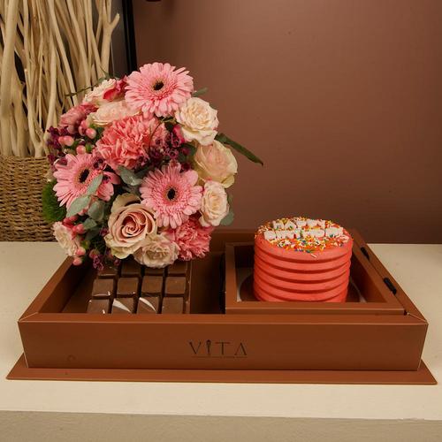 Rondo - This box contains a chocolate cake and 12 pieces of chocolate, with an arrangement of roses, gerberas, and carnations.