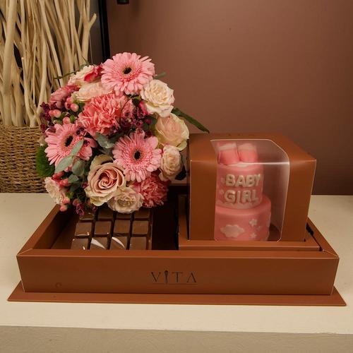 Shaikha - This box contains a chocolate cake and 12 pieces of chocolate, with an arrangement of roses, gerberas, and carnations.