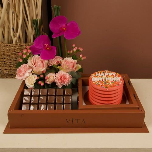 Lolo - A box that contains 300 grams of chocolate and pink cake with still grass, pink baby roses and pink hypericum.