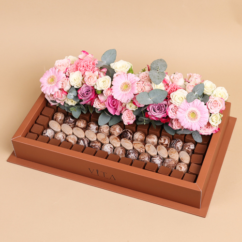 Glaze - A box that contains 1 kilo of chocolate with a flower arrangement of gerbera, baby roses and green leaves.