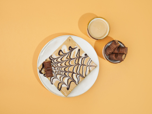 Kinder Benuo Crepe - thin type of pancake flavored with kinder sauce garnished with Belgian dark and white chocolate with a bites of kinder bar and hazelnuts