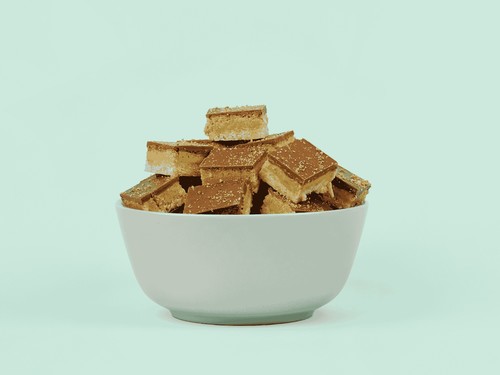 Kunafa Bites - A crushed Kunafa mixed into pistachio cream topped with chocolate garnished with ground pistachio nuts.