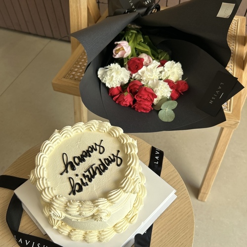 Lavish Flowers - RoseBlast - It contains a bouquet of fuchsia baby roses, carnations, and tulips, along with a lavish cake with Happy Birthday writing.