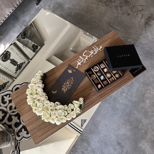 Lavish Flowers - Neqsa Helal Ramadan - contains a small crescent-shaped rose, a 200-gram box of chocolates, and a greeting card.