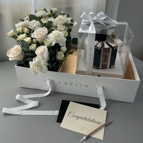 Lavish Flowers - Graduation Box - It contains roses, a carnation, and a baby rose,  with a graduation cake, one candle, and a congratulations card.