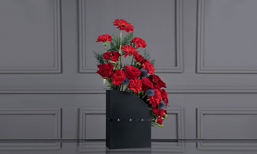 Crimson Bouquet - A stand of big roses, carnations, gerbera and erengium with mix of leaves.
Height: 60 cm, Width: 40 cm