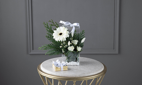 Jenny I - The bouquet contains gerbera, baby roses, confern leaves and wax flowers with Belgian chocolates.
Height: 22 cm, Width: 10 cm