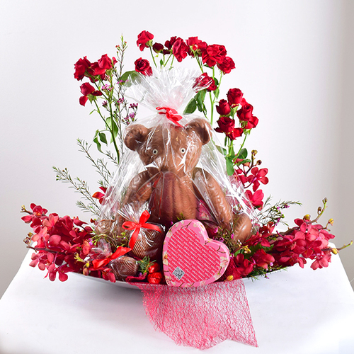 You & Me 36 - acrylic
  tray with fresh orchid and wax flower with teddy bear and hearts chocolate .