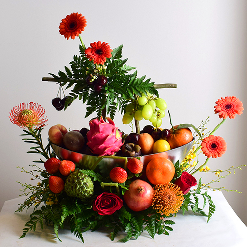 al khayal 1 - acrylic
  tray with a decoration of fresh gerbera, roses and pins flowers with assorted
  mixed fresh fruits.