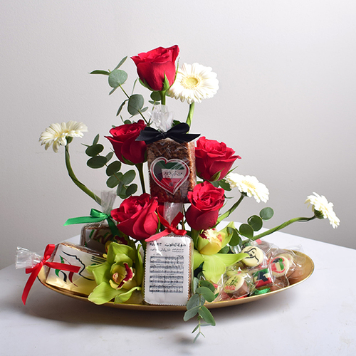 al khayal 11 - acrylic
  tray with a decoration of fresh , roses and gerbera flowers with rice crispy
  and chocolates.