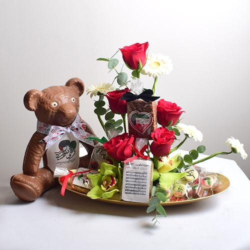 al khayal 12 - acrylic
  tray with a decoration of fresh roses, cymbidium and gerbera flowers with
  rice crispy, Big teddy bear chocolate and chocolates.