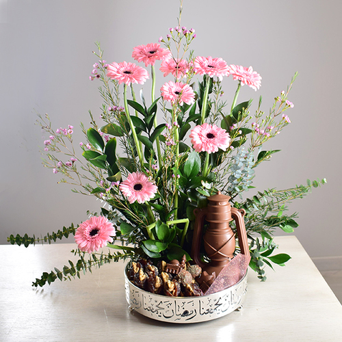 Ramadan Yijmana 41 - silver
  round tray with fanoush chocolate, dates with nuts and Ramadan chocolates
  with a decoration of fresh gerbera and wax flowers.