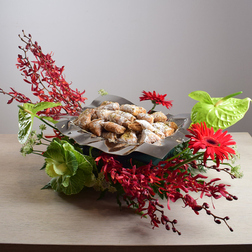 Ramadan Yijmana 60 - silver
  tray with kuwaiti sweets with a decoration of fresh gerbera, orchid and
  anthorium flowers.