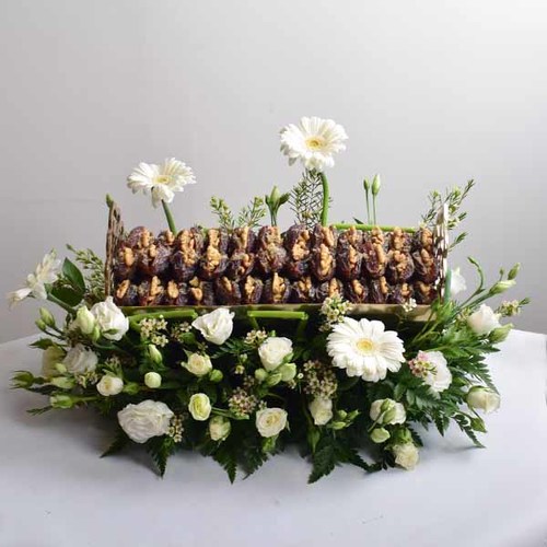 Al Eid 2 - silver
  tray with dates and a decoration of fresh gerbera and lisianthus flowers.