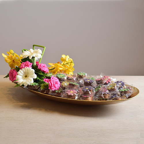 chocolate tray 2 - acrylic gold tray with  kilos of chocolates and a decoration of
  fresh gerbera, roses and orchids.