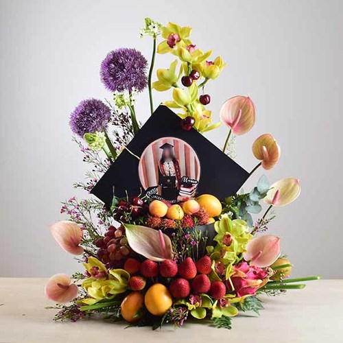 congrats 3 - Costumized
  Graduation cap box with mixed fresh fruits and a decoration of fresh
  cymbidium, anthorium, allum and wax flowers.