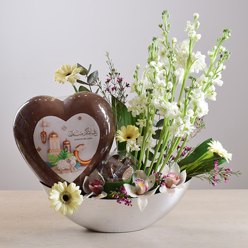 eid adhha & haj mabror 16 - big
  heart shape eid al adha design chocolate on a tray with chocolates and a
  decoration of fresh  baby orchid,
  gerbera, cymbidium and wax flowers.