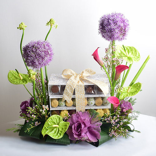 eid adhha & haj mabror 23 - 3
  layer acrylic tray of kuwaiti sweets and chocolates with a decoration of
  fresh allu, anthorium, gerbera and wax flowers.