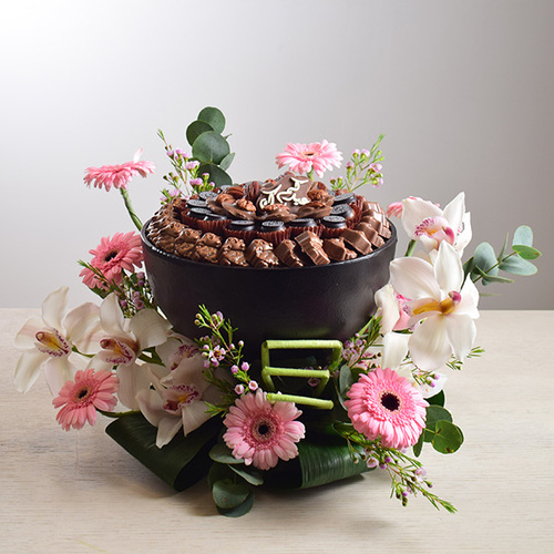 eid adhha & haj mabror 25 - tray
  of chocolates with a decoration of fresh cymbidium, gerbera and wax flowers.