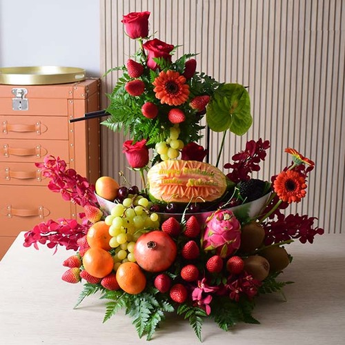 someone special 5 - An
  acrylic tray with a decoration of gerbera, roses and orchid flowers with
  assorted mixed fruits and papaya carving.