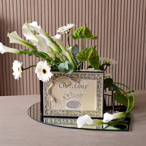 Wedding book - Wedding
  Guest book with pen on a heart mirror tray with a decoration of fresh
  gerbera, calla, and anthorium flowers.