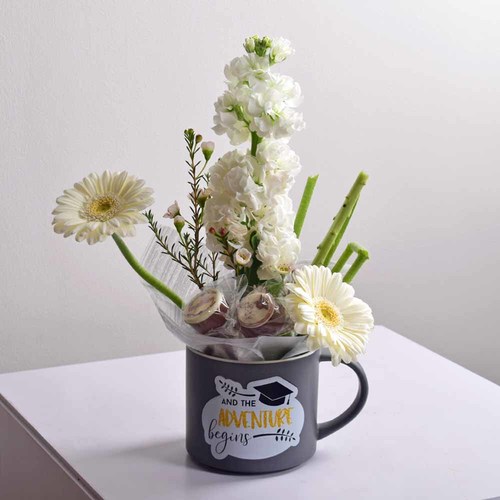 Graduation Gift 2 - Graduation
  mug with a decoaration of fresh gerbera, matola and wax flowers with
  chocolates.