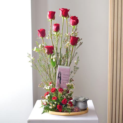 Anta Auomri 10 - round
  golden tray with rose design candle holder, chocolates, Chocolate bar and a
  decoration of fresh roses and wax flowers.