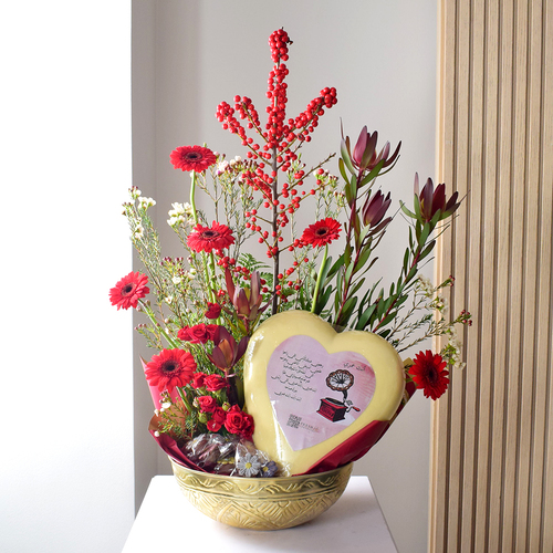 Anta Auomri 15 - golden
  bowl with big heart chocolates, small chocolates and a decoration of fresh
  gerbera, baby roses, hyperecum and wax flowers.