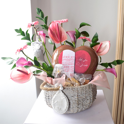 Anta Auomri 19 - basket
  with bif heart chocolates with electric lamp, cookies, brownies and
  acssesories with a decoration of fresh gerbera, calla, anthorium and greens.