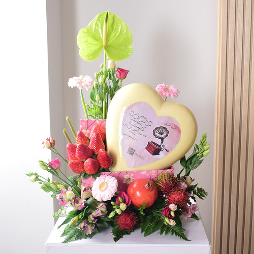 Anta Auomri 24 - big
  heart chocolate with fresh strawberries,rambutan, pomegranate and a
  decoration of fresh lisianthus, gerbera and anthorium  flowers on a pink box.