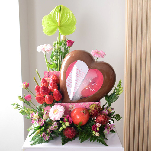 Anta Auomri 25 - big
  heart chocolate with fresh strawberries,rambutan, pomegranate and a
  decoration of fresh lisianthus, gerbera and anthorium  flowers on a pink box.