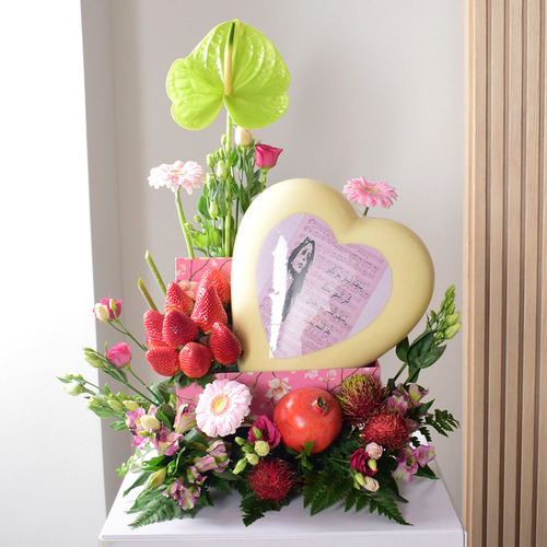 Fresh Couture - Anta Auomri 26 - big
  heart chocolate with fresh strawberries,rambutan, pomegranate and a
  decoration of fresh lisianthus, gerbera and anthorium  flowers on a pink box.