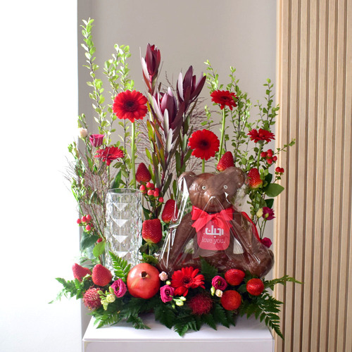 Anta Auomri 27 - chocolate
  teddy Bear with LED lamp, pomegranate, strawberry, rambutan and a decoration
  of fresh baby rose, gerbera, lisianthus, safari and wax flowers.