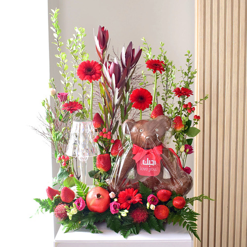 Anta Auomri 28 - chocolate
  teddy Bear with LED lamp, pomegranate, strawberry, rambutan and a decoration
  of fresh baby rose, gerbera, lisianthus, safari and wax flowers.