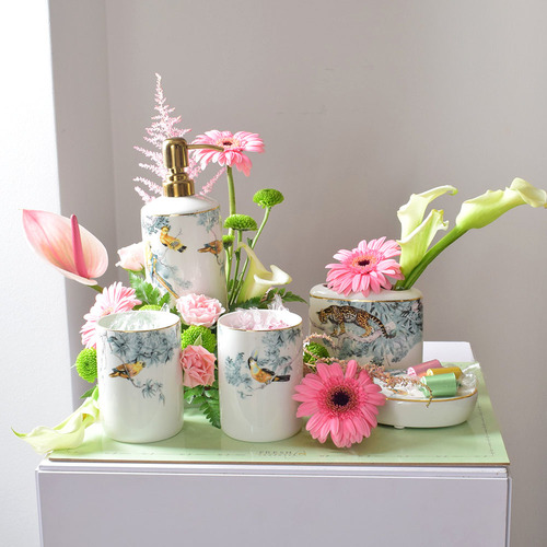 Me & You 33 - ceramic
  bathroom set with chocolates and a decoration of fresh gerbera, calla,
  chrysanth, lisaianthus and astilbe flowers on a carton tray.