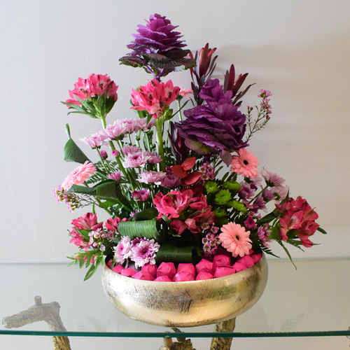 Garden - gold
  tray with kilos of chocolates, fresh pink and purple flowers like brassica,
  gerbera, astromeria, wax flowers and chrysanthemums.