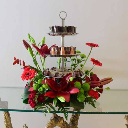 2026 - Ramadan 2 - 3
  layers silver tray with Ramadan design chocolates with a decoration of fresh
  gerbaera, lilium, baby roses and chrysanthemum flowers.