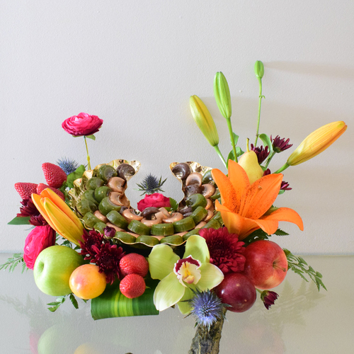 Helal Al Eid 1 - moon
  shape aluminum tray with eid chocolates and a decoration of fresh cymbidium,
  lilium, erygeum, flowers with mix fruits.