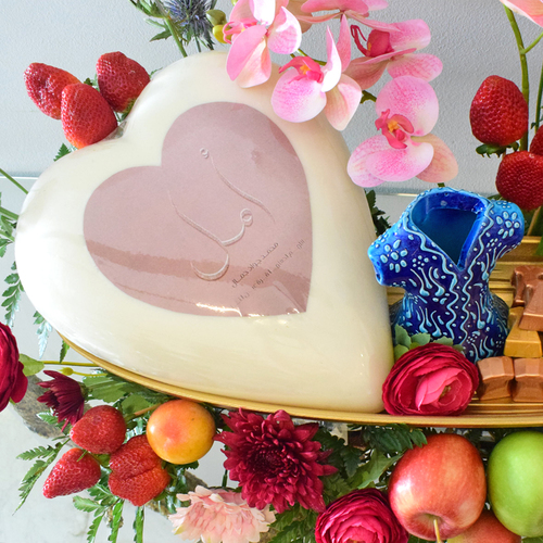 Amal Hyatti - Mothers
  day (costumized name of the mom) Heart chocolate with mix chocolates and mix
  fruits with ceramic kaftan and fresh & artificial gerbera, hydraengea,
  peonia, cybidium.