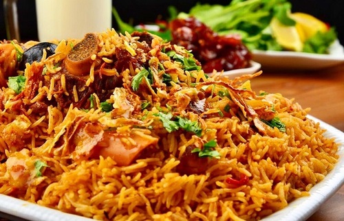 Kabsa Platter - Piece, served with red rice, maabouj and broth.