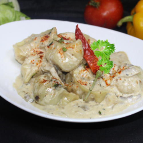 Momo with Creamy Mushroom - Homemade momo stuffed with mixed marinated mutton and served in creamy mushroom sauce.