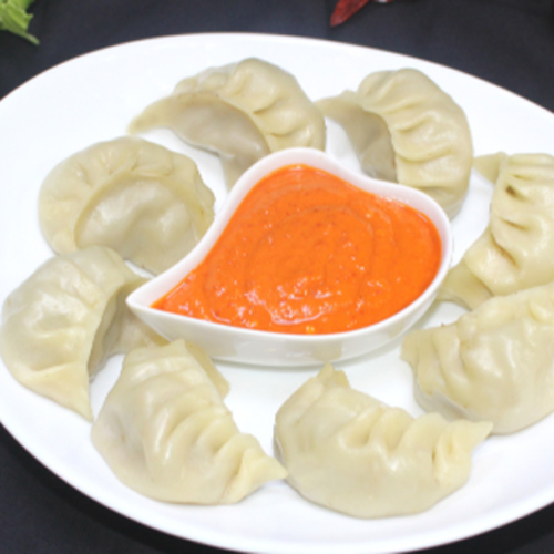 Momo - Homemade momo stuffed with mixed marinated mutton and served with light spicy tomato sauce.