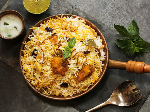 Hyderabadi Chicken Biryani - Half boiled rice layered with fried onions, mint, cooked chicken, sealed with dough and slow cooked 'dum' style