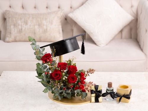 Graduation - The arrangement contains big roses, baby roses, eucalyptus and hyprecum in addittion to chocolate, perfume and mubkhar. Height: 40 cm, Width: 34 cm