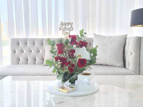 Father's Day - The arrangement contains big roses, baby roses, cut flower, eryngium, eucalyptus, and wax flower in addition to Mubkhar, Belgian Chocolates, and Topper. 
 Height: 40 cm, Width: 30 cm