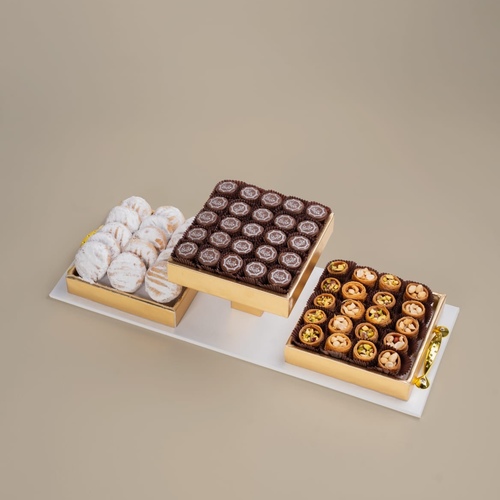 Eid Trio - A wooden triple stand combining three delicious varieties of Eid Kahk, Osh El Bolbol sweets, and Belgian chocolates, with 'Eidkum Mubarak' printing, carefully selected to offer a unique taste experience celebrating the Eid atmosphere.