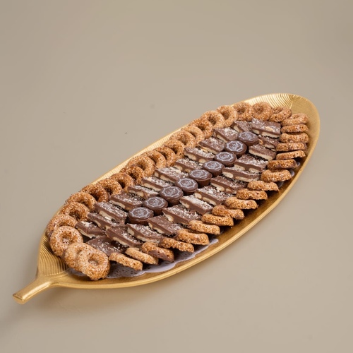 Tree leaves, Eid Mubarak - A luxurious tray shaped like tree leaves, meticulously prepared with Belgian chocolate, sesame sweets, and an Eid Mubarak print, made from the finest ingredients for special occasions