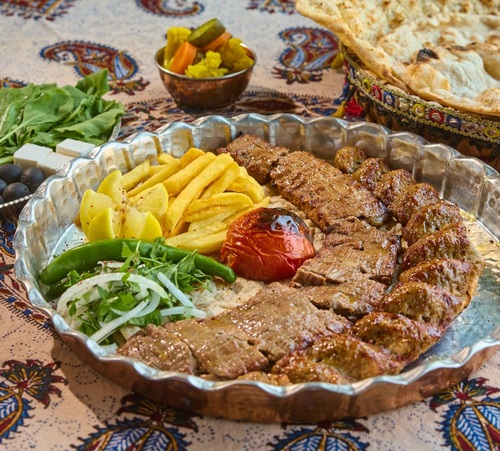 kebab sultani - A meal consisting of 1 kobideh kebab skewer and 1 barak kebab skewer, served with french fries, grilled tomatoes and tanour bread.