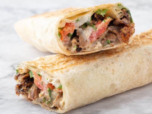 Meat Shawarma Saj Sandwich - Meat shawarma, onion, parsley, tahini and tomato.